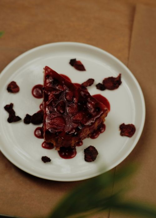 Free Slice of cherry cake topped with rich sauce on a white plate. Perfect for dessert lovers. Stock Photo