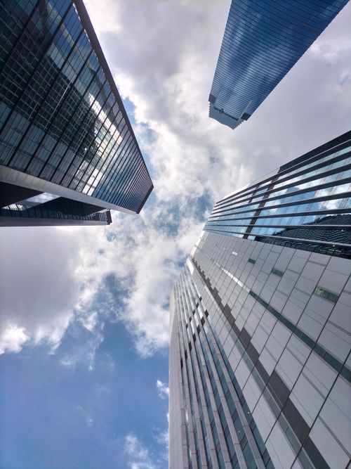 Free Looking up at Kuala Lumpur skyscrapers with dramatic clouds and reflections in the glass facades. Stock Photo