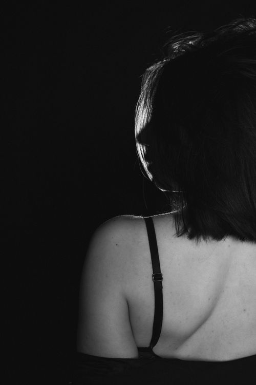 Free A black and white silhouette of a woman in a studio setting, emphasizing form and shadow. Stock Photo