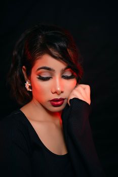Portrait of a young woman with glamour makeup and red lips in a studio setting.
