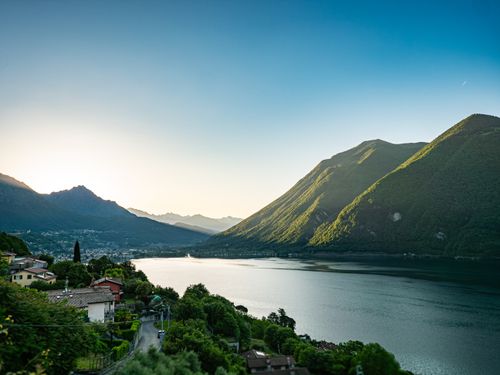 Free Breathtaking view of Lake Lugano at sunset with mountains and reflection in Porlezza, Italy. Stock Photo