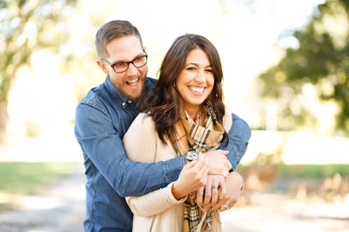 Free Portrait of Happy Young Woman Using Mobile Phone in City Stock Photo