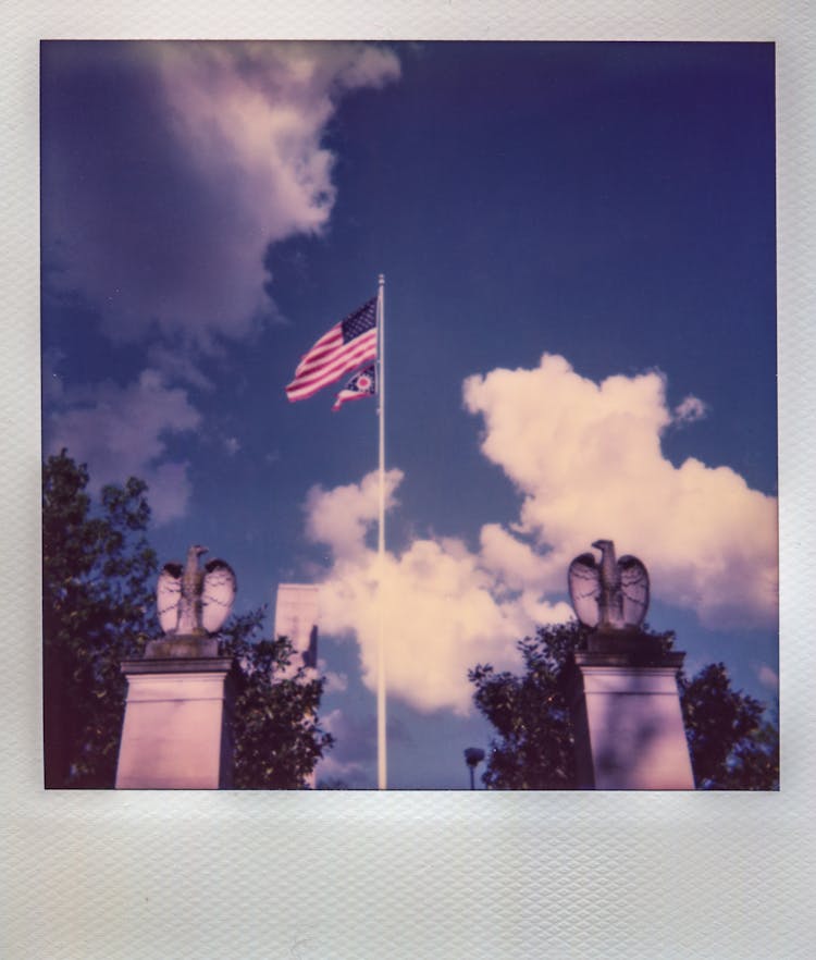 American Flag Flying On Pole Between Two Eagle Statues