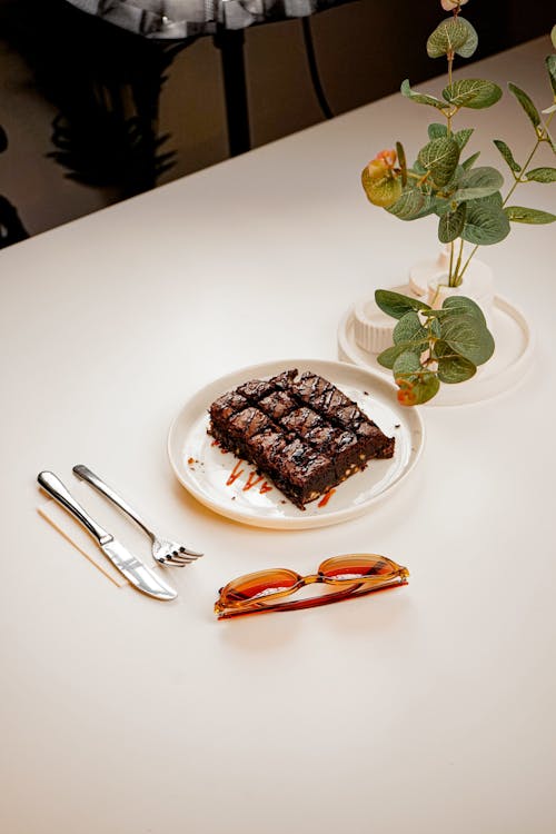 A plate of brownies with a fork and knife