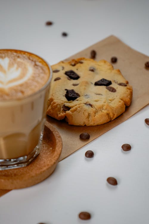 A cup of coffee and a cookie on a table