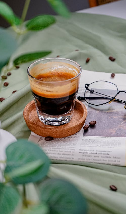 A cup of coffee with a book and glasses