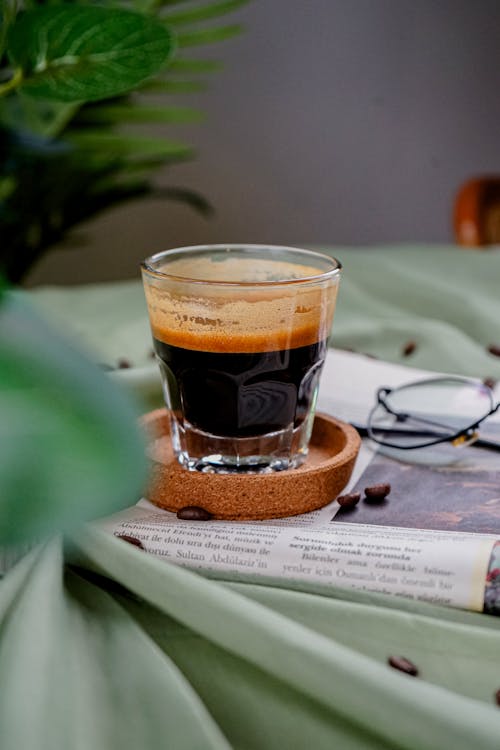 A glass of espresso sits on top of a table