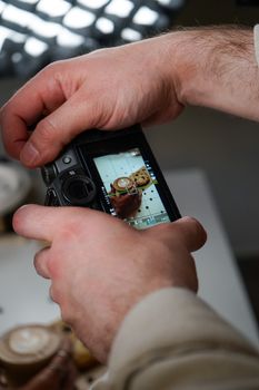 Hands adjusting DSLR camera settings for a close-up shot during a daytime indoor session.