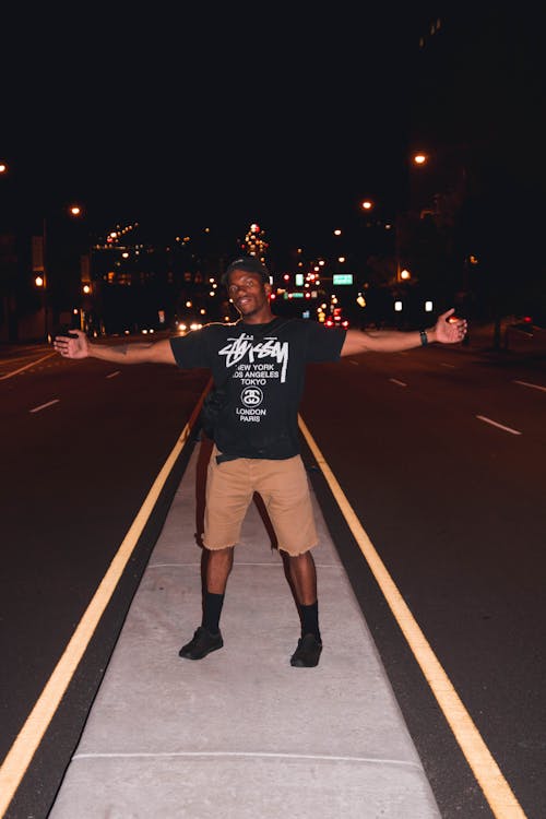 Free Man Standing in a Road during Nighttime With Lights Stock Photo