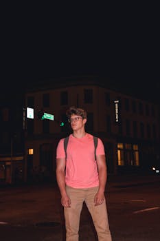 晚上，一个背着背包的年轻人站在里士满的街道上，散发出一种随意的氛围