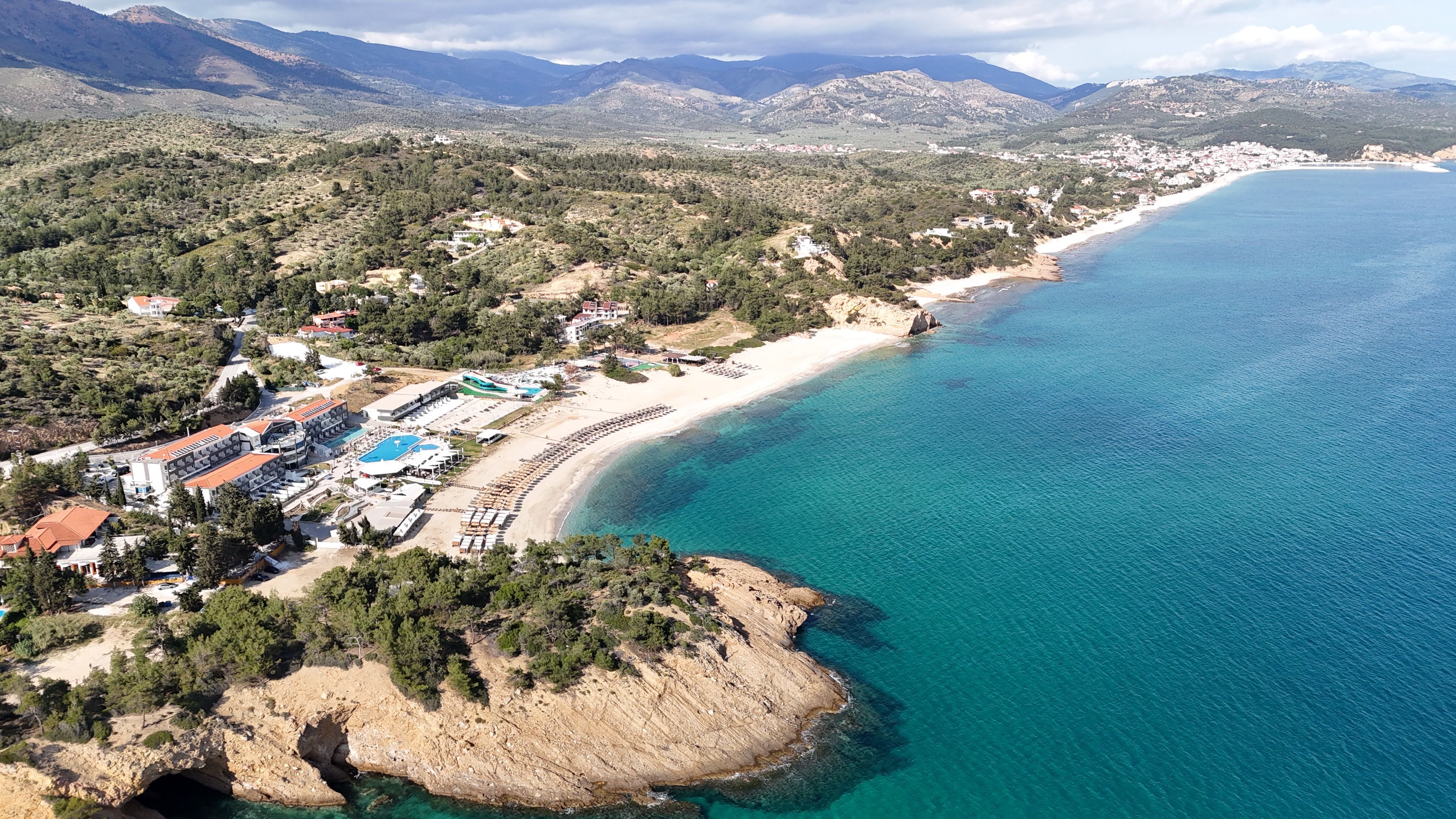 Stunning aerial view of a coastal resort with turquoise waters and lush landscapes, perfect for summer vacations.