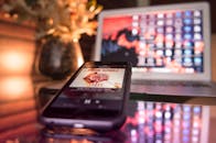 现代化的工作空间配备智能手机和笔记本电脑，灯光明亮且具有反光效果