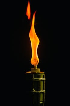 黑色背景下，火炬点燃，橙色火焰的特写