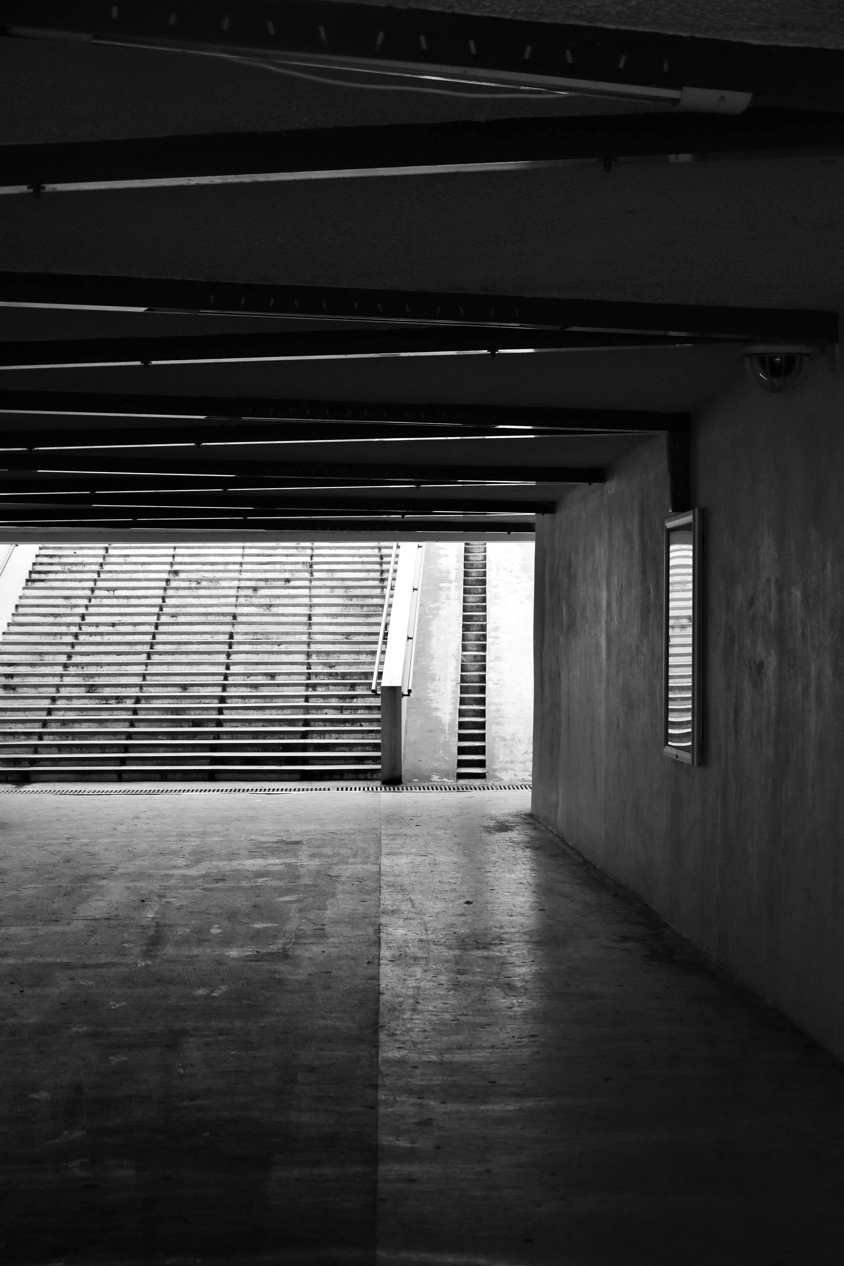 Monochrome view of a concrete metro passageway with leading stairs.