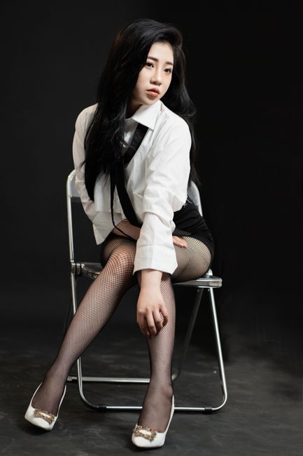 Stylish portrait of a young woman posing fashionably in a studio setting.