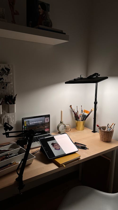 A desk with a lamp and a laptop on it
