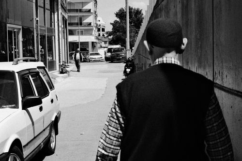 Free Black and white photo of a street in Bursa, showcasing an urban scene with cars and pedestrians. Stock Photo