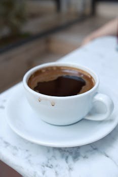 Close-up of a steaming cup of Turkish coffee on a marble table in Bursa, Türkiye.