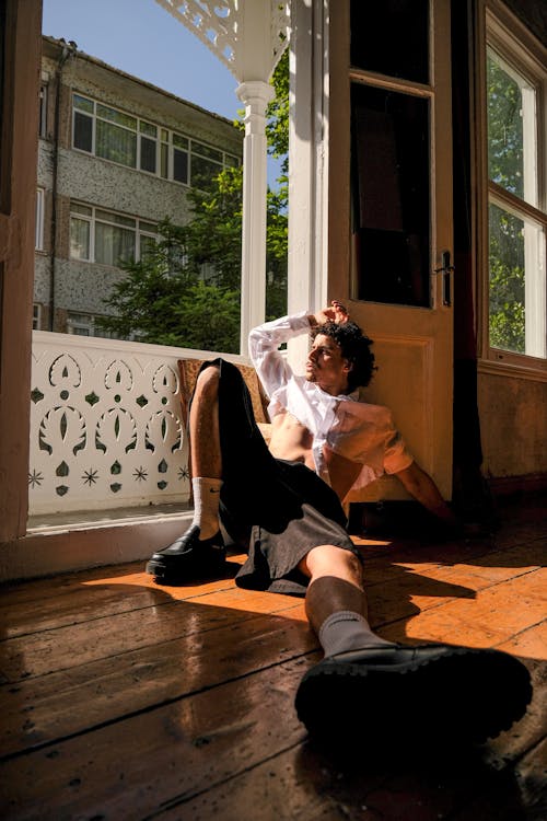 A young man laying on the floor in front of a window