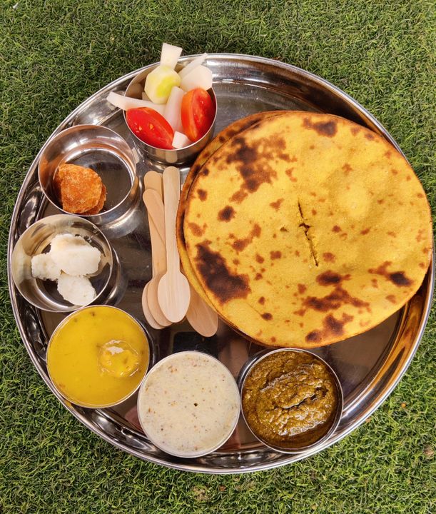 How to Start a Catering Business in Ahmedabad: A 2026 Step-by-Step Guide 2 A beautifully arranged Indian vegetarian thali with vibrant curries, dal, rice, rotis, and sweets served on a silver plate.