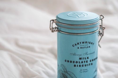 A canister of milk and chocolate on a bed