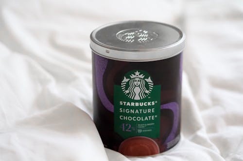 Starbucks coffee in a tin on a bed