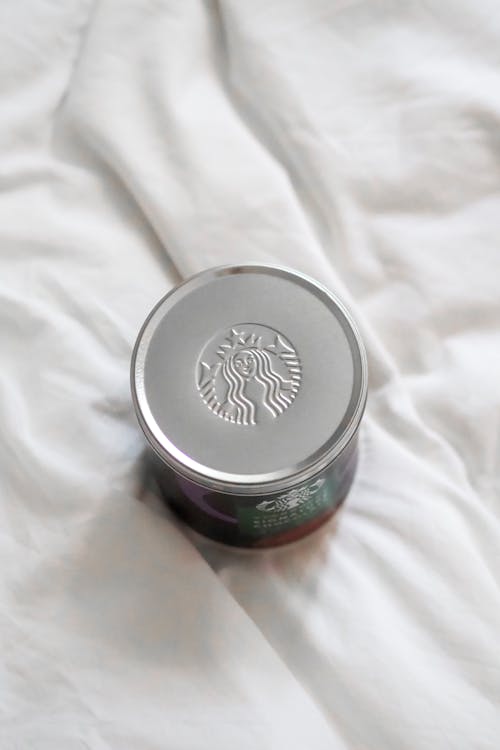 Starbucks coffee tin on white bed
