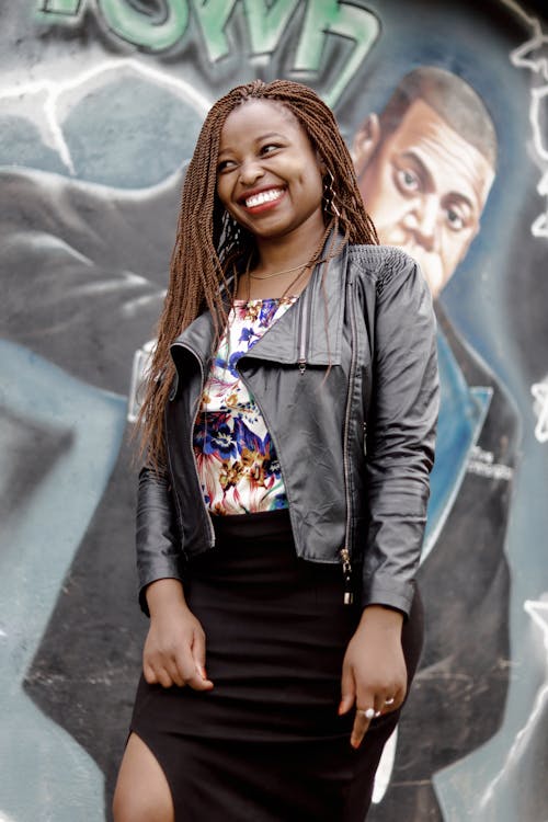 Free Photo of Smiling Woman Standing Near Graffiti Wall Stock Photo