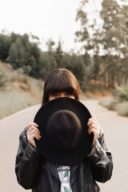 Mysterious woman with hat standing on a deserted road in Rio Vermelho.