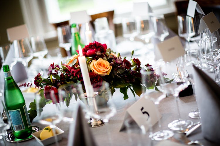 נר דולק וסידור פרחים על שולחן אירוע