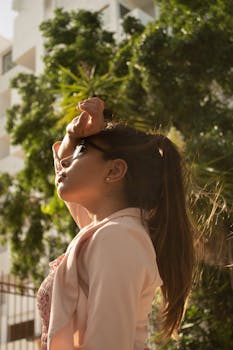 一位时尚女士戴着太阳镜，在户外摆姿势，享受阳光和夏日气息