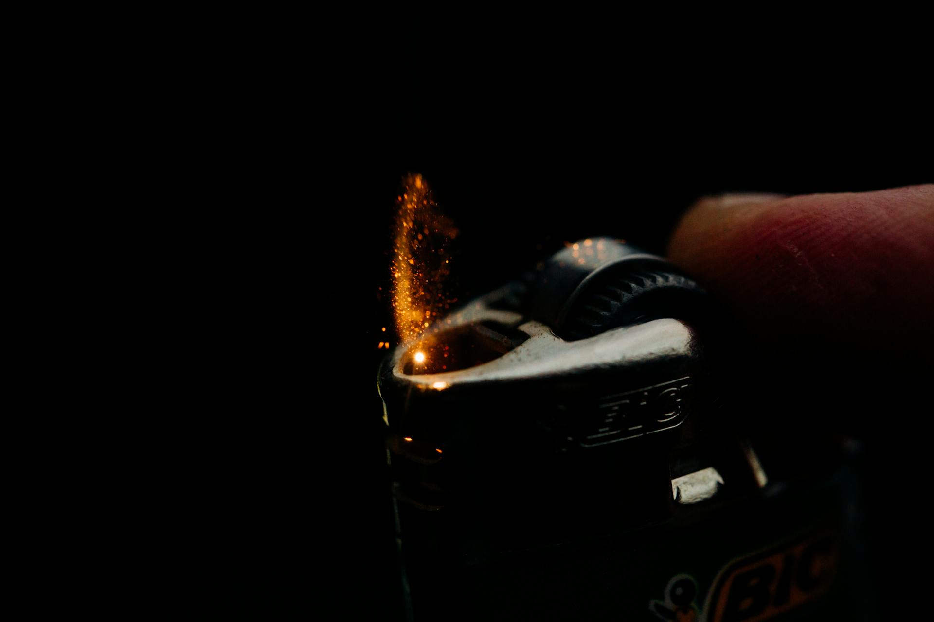 Close-up of a Bic lighter igniting with sparks against a dark background. Captures the essence of fire and ignition.