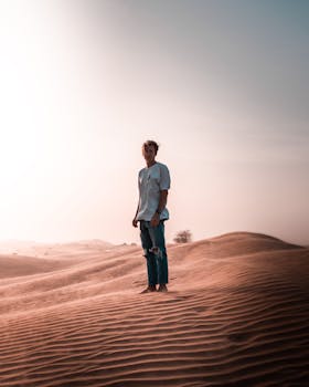 广阔的沙漠沙丘上，一个孤独的人站在柔软温暖的天空下