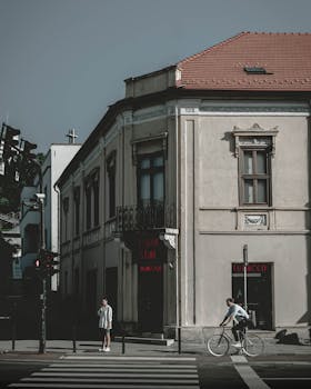 Charming street scene in Cluj-Napoca featuring historic architecture and a cyclist.