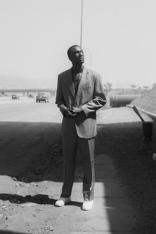 A man in a suit standing on a road
