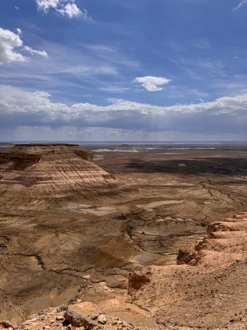 Free Breathtaking view of the Grand Canyon's arid terrain under a vibrant blue sky with scattered clouds. Stock Photo
