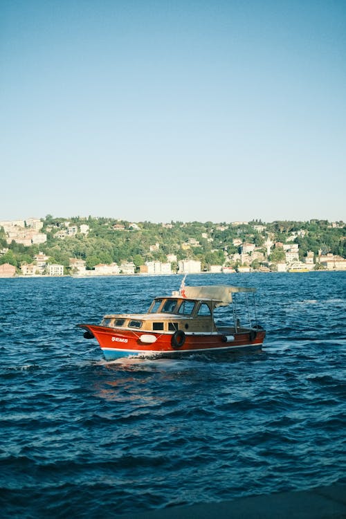 A boat traveling on the water near a city