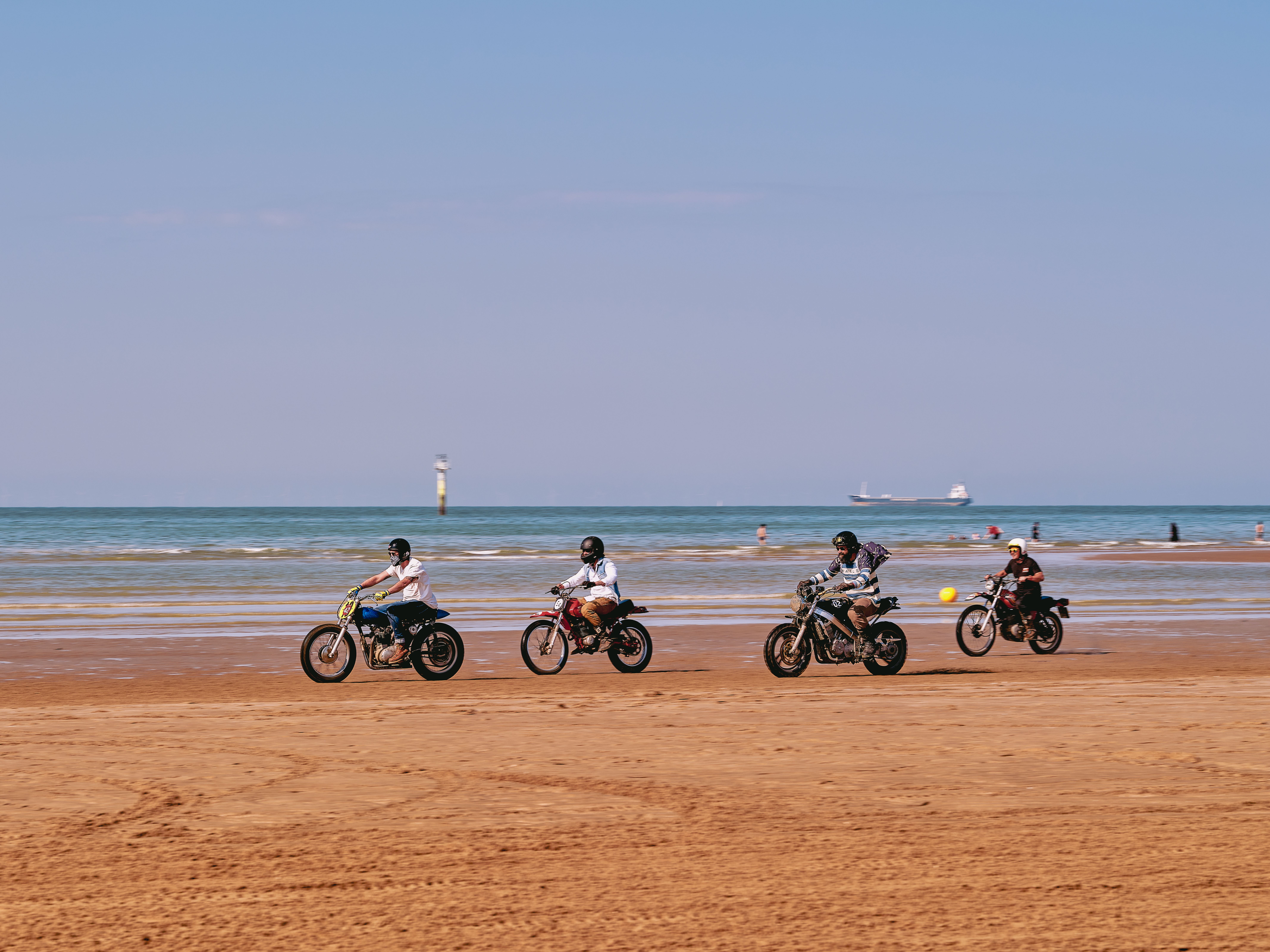 A group of motorcyclists enjoying a sunny ride along Margate Beach, England.