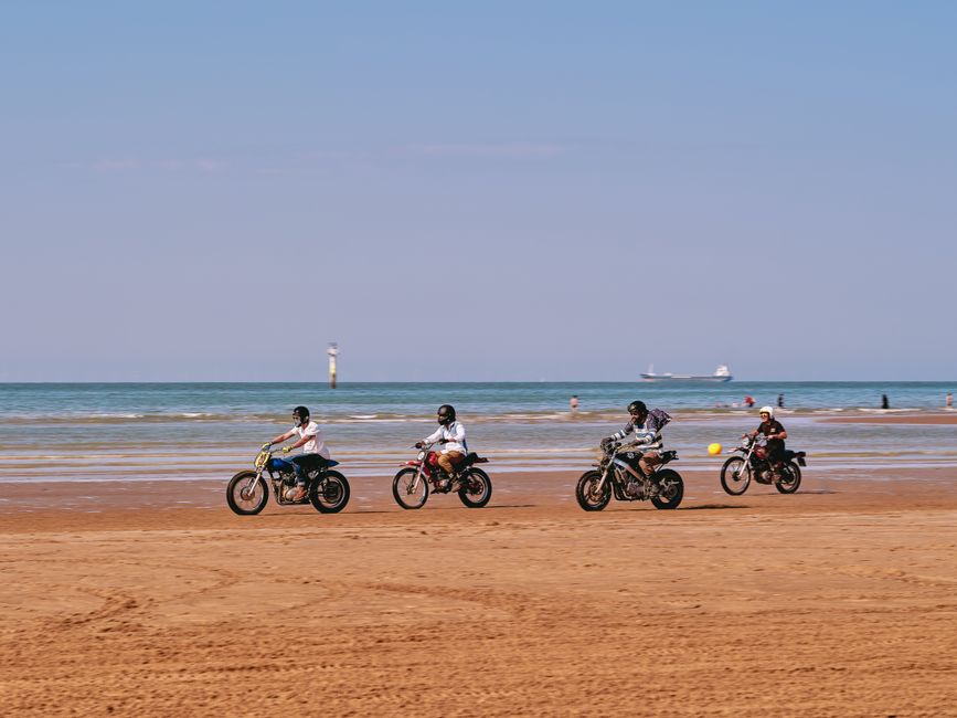 A group of motorcyclists enjoying a sunny ride along Margate Beach, England.
