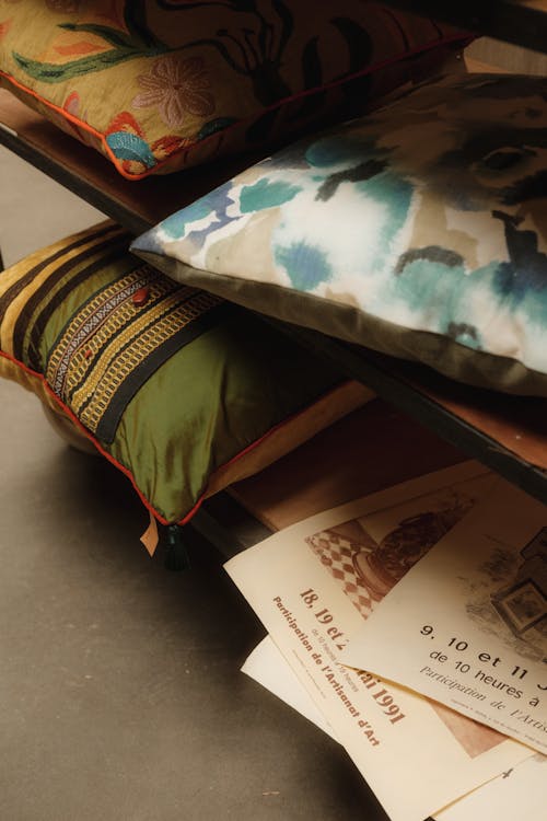 A shelf with several pillows and books on it