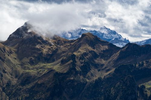 Free A stunning view of mountainous peaks partially covered by clouds, showcasing nature's grandeur. Stock Photo