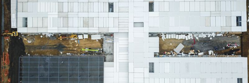 Drone shot capturing aerial view of a large construction site with unfinished buildings.