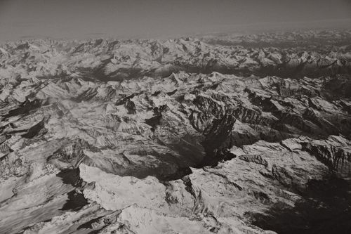 Free Black and white aerial photo of a vast snowcapped mountain range under clear sky. Stock Photo