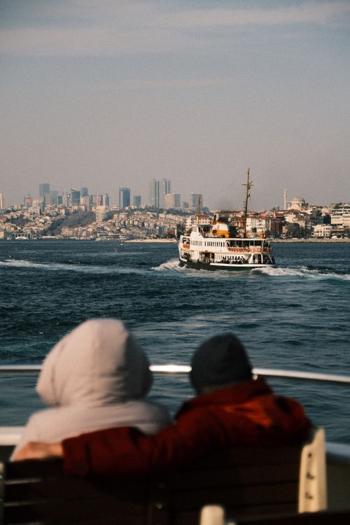 Free Couple enjoying a ferry ride with a view of Istanbul's skyline across the Bosporus. Stock Photo
