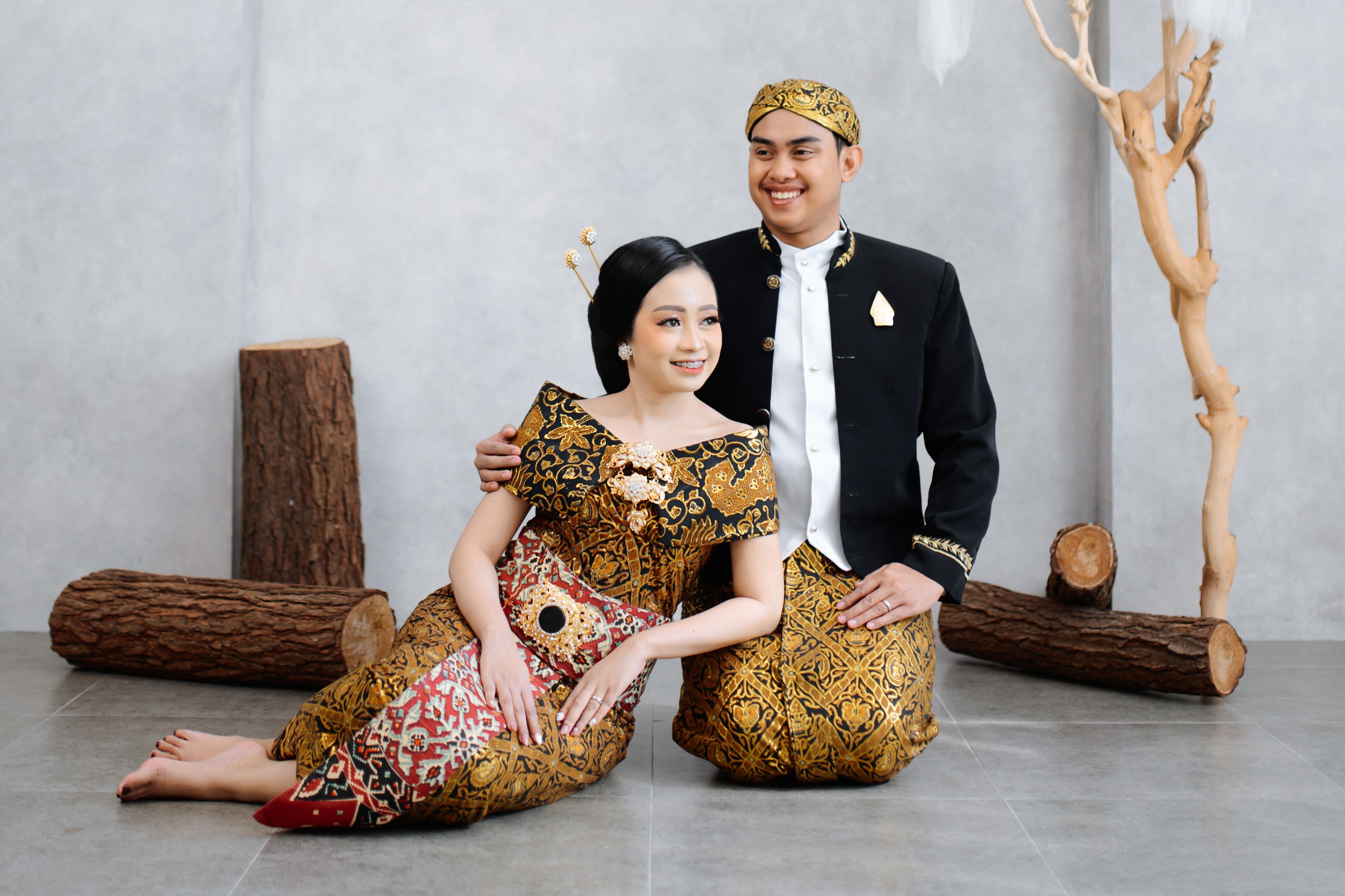 Smiling Couple Sitting in Traditional Clothing · Free Stock Photo