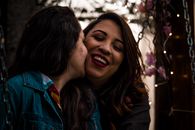 Smiling Women Kissing Anotherwoman