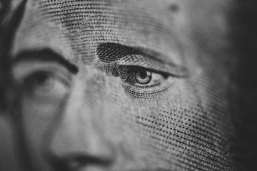 Extreme close-up of an engraved eye on a paper currency note, highlighting intricate details.