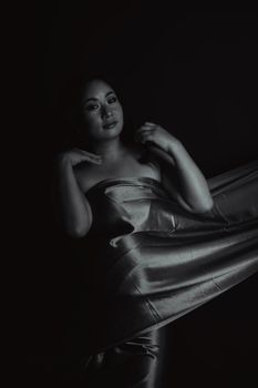 Stylish black and white portrait of a woman draped in fabric, exuding elegance.