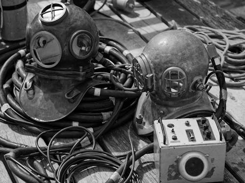 A black and white photo of a diving helmet and other equipment