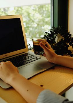 A woman enjoying coffee while working on a laptop in İstanbul office space.